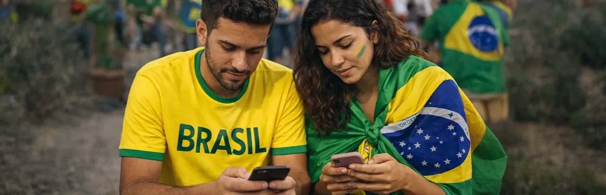 A couple of young Brazilians are sitting, using VPN on their smartphones to access social media