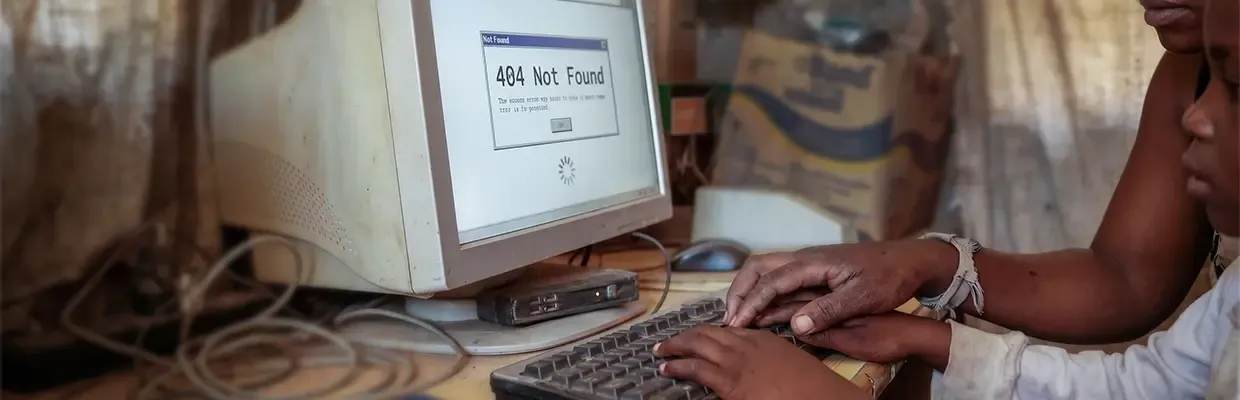 An image of two children using an old computer that displays a 404 error