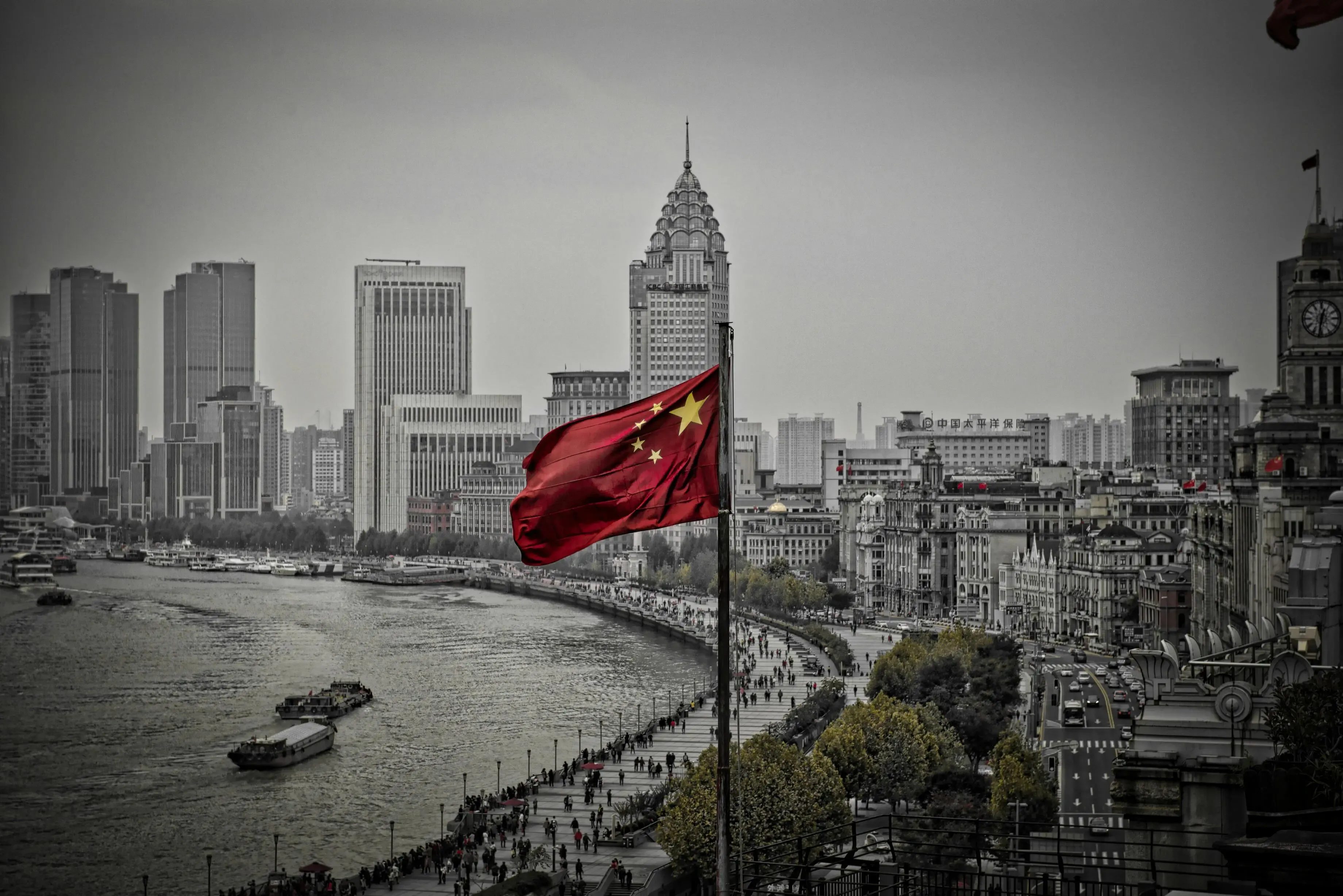 An image of the China flag waving over a major city landscape