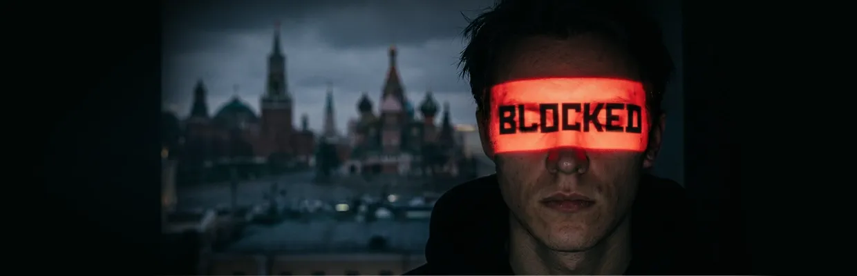 An image of a man in the shadows with his face hidden by the word "BLOCKED"